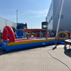 Lange opblaasbare buikschuifbaan van 15 meter met kleurrijke bogen en waterstrook.