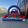 Een rood-blauwe stormbaan van 10 meter lang met diverse hindernissen, waaronder een tunnel, obstakels en een klim-/springgedeelte, geplaatst op een kleurrijk opblaasbaar platform.