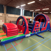 Inflatable stormbaan Take Out van 14,5 meter met diverse hindernissen en glijbaan, gefotografeerd vrijstaand.