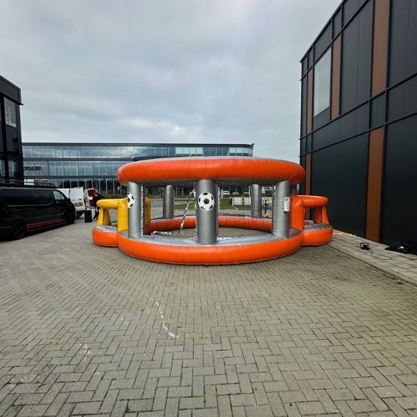 Opblaasbare Panna Voetbal Arena in oranje en grijs, gezien vanaf de voorkant, ideaal voor sportieve verhuur en panna-wedstrijden.