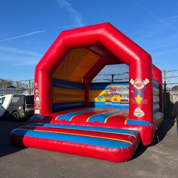 Rood circus springkussen met overkapping en kleurrijke springvloer, ideaal voor verhuur op kinderfeestjes en evenementen.