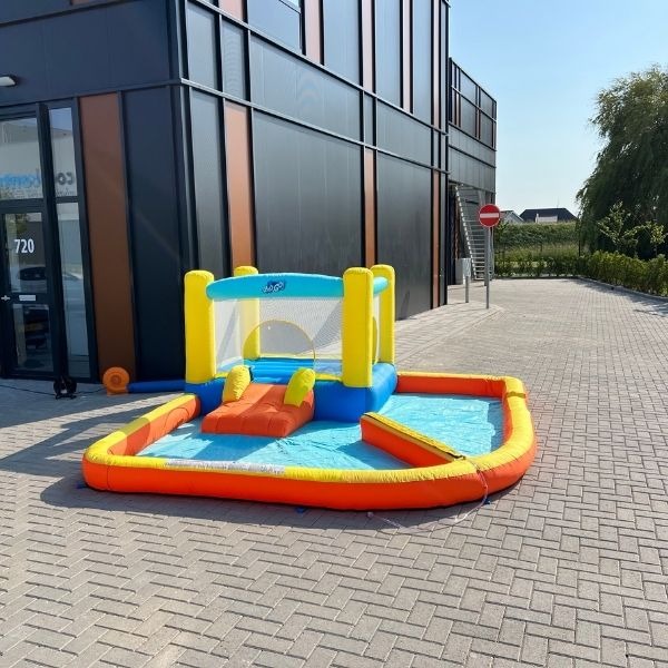 Opblaasbaar mini waterkasteel met glijbaan en plonsbad, geschikt voor jonge kinderen.