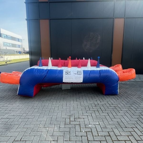 Opblaasbaar zweefbal spel in rood, blauw en wit met meerdere luchtkegels, gezien van voren.