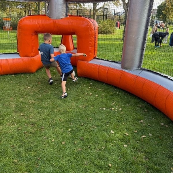 Opblaasbare Panna Voetbal Arena in oranje en grijs, gezien vanaf de voorkant, ideaal voor sportieve verhuur en panna-wedstrijden.