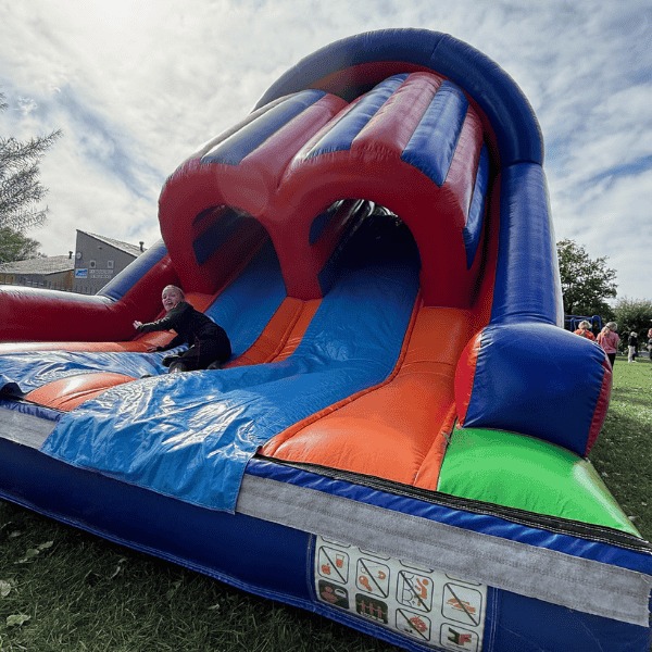 Inflatable stormbaan Take Out van 14,5 meter met diverse hindernissen en glijbaan, gefotografeerd vrijstaand.