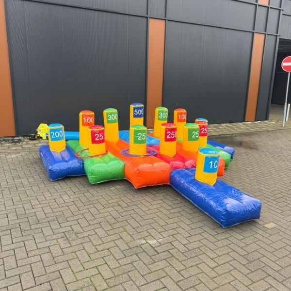 Ringgooien opblaasbaar Opblaasbaar ringgooien spel met gekleurde puntenblokken en ringen, opgesteld op straat.